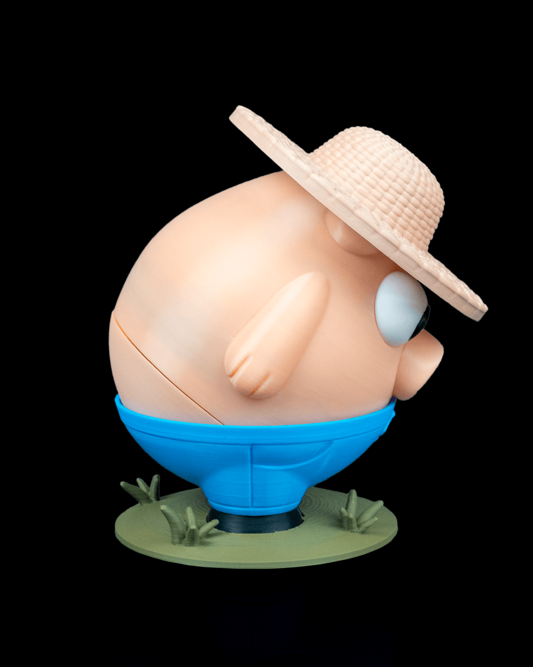 Spherical character with a straw hat and blue base on a black background